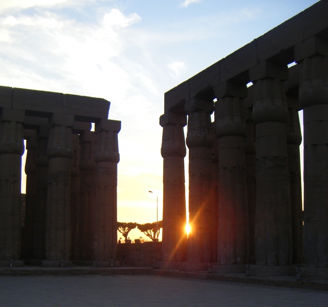 The sun setting through columns at Luxor Temple.