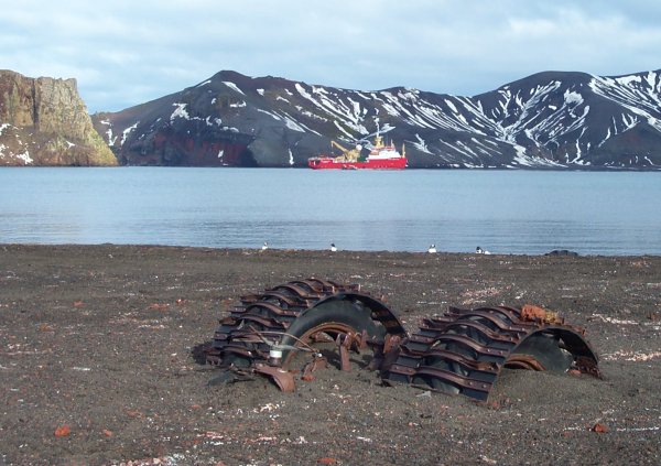 A tractor from the 60's buried in volcanic mud after Deception Island's 1969 eruption with the RRS Shackleton in the background.