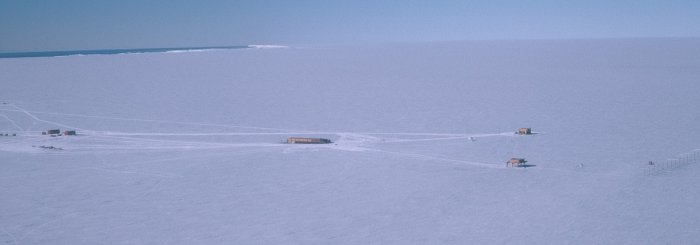 An shot of Halley taken from a Twin Otter to the west of the base. The coast is visible in the top-left. The building in the centre is the main Laws accomodation building. To the left of this are the Garage and summer accomodation building. To the right are the Simpson and Piggott science buildings and the SHARE radar is to the right of these.